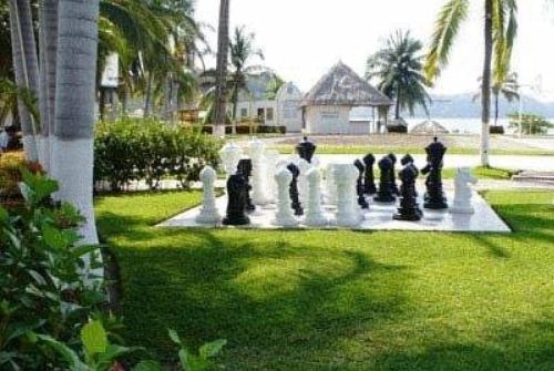a group of people playing chess on a giant chessboard at Qualton Club Ixtapa All Inclusive in Ixtapa