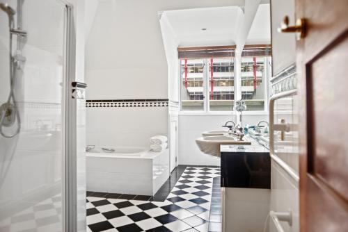 a white bathroom with a black and white checkered floor at Wellesley Boutique Hotel in Wellington