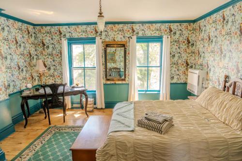 a bedroom with a bed and a desk and windows at Gould Swaby Mansion in Seneca Falls