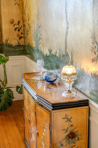 an old wooden cabinet with a painting on the wall at Gould Swaby Mansion in Seneca Falls