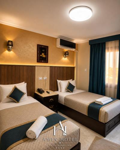 a hotel room with two beds and a tv at Amin Hotel Cairo Downtown in Cairo