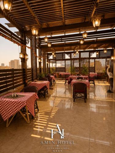 a restaurant with tables and chairs in a building at Amin Hotel Cairo Downtown in Cairo