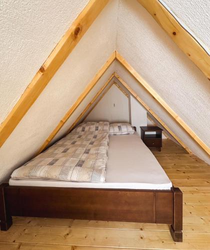 a bed in the middle of a loft at Apartmani Vila Zabljak in Žabljak