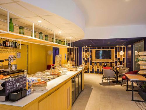 a restaurant with a counter with food on it at ibis Belfort Danjoutin in Belfort
