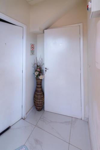 a vase of flowers sitting next to a door at Casa do Henrique 1 in Sorocaba