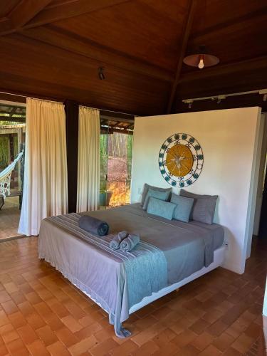 a bedroom with a bed with a clock on the wall at Pousada Vila de Charme in Lençóis