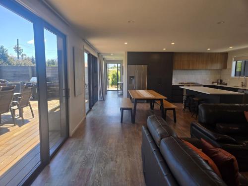 a living room with a couch and a table and a kitchen at Totara Haven in Twizel