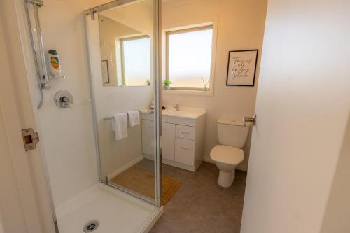 a bathroom with a shower and a toilet at Relax on Rata, Cottage 2 in Twizel