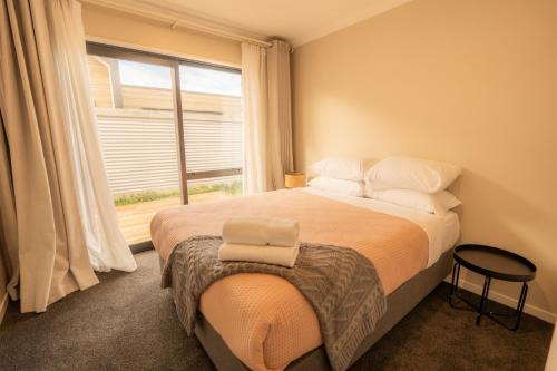 a bedroom with a large bed with a window at Heavenly Hideaway, House B in Twizel