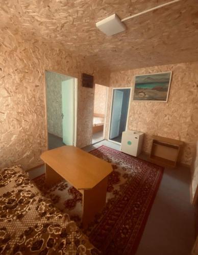 a room with a wooden table and a rug at Aragast White Beach in Sevan