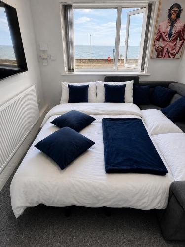 a large bed with blue pillows on it in a bedroom at Sea-View Luxury Apartment sleeps 5 - Pet Friendly - Fast WiFi - Off Street Parking - Contractors Dream!!! in Sheerness