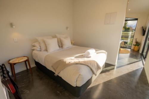 a bedroom with a bed with white sheets and pillows at Ben Ohau Views The Studio in Twizel