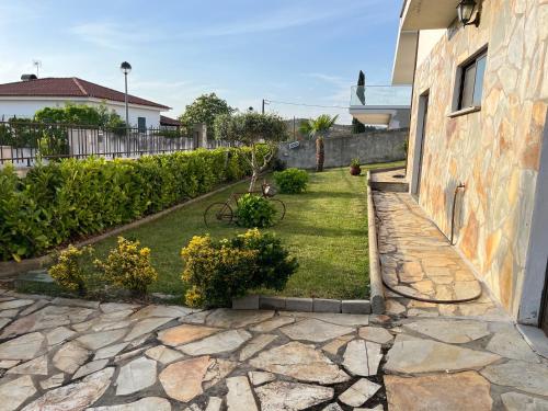 a yard with a stone walkway next to a house at Alojamento, Chelas Rural AL in Mirandela