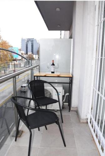 a balcony with two chairs and a table on a building at @juanbjustoapartamento in Buenos Aires