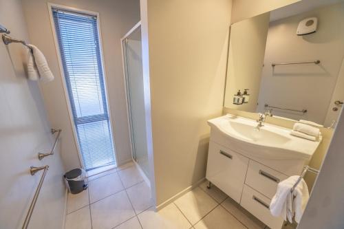 a white bathroom with a sink and a mirror at Irishman Drive Escape in Twizel