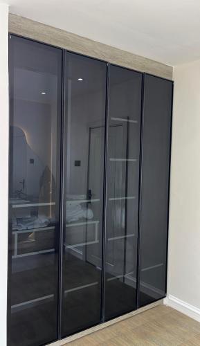 an empty room with black glass cabinets at NobleStaysTz in Dar es Salaam