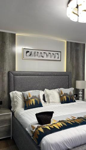 a bedroom with a large bed with white sheets at NobleStaysTz in Dar es Salaam