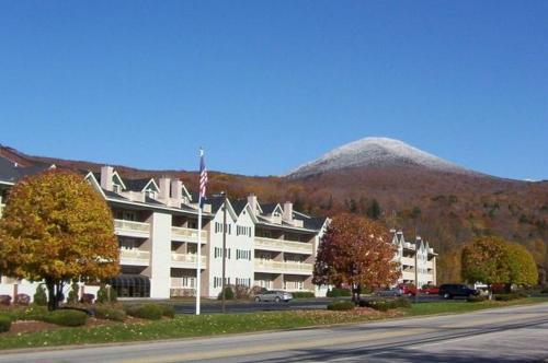 a large apartment building with a mountain in the background at Nordic Inn Condominium Resort in Lincoln