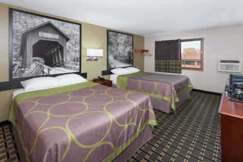 A bed or beds in a room at Super 8 by Wyndham Michigan City