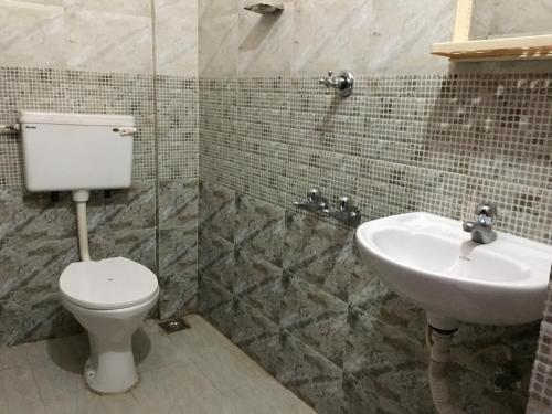 uma casa de banho com um WC e um lavatório em Mega Tourist Home em Guruvāyūr