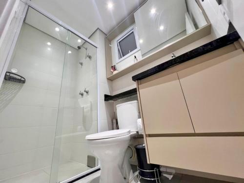 a bathroom with a toilet and a glass shower at Apartamento 2 quartos com Vista in Bauru