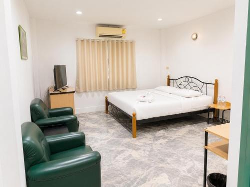 a bedroom with a bed and a chair and a tv at โรงแรมลักเซอรี่ Luxury Hotel in Kanchanaburi City