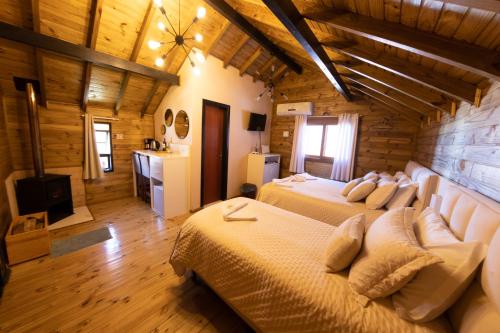 a bedroom with two beds in a wooden house at Cabanas Charme da Serra in Cambará