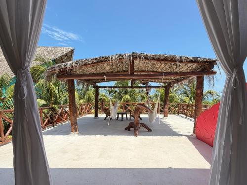 a pavilion with a table and a monkey under it at Palapas del Sol in Holbox Island