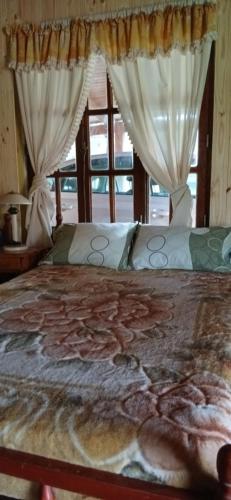 a bed with a blanket with a picture of animals on it at Cabaña Familiar con arroyo sobre Ruta 12 II in Santa Ana