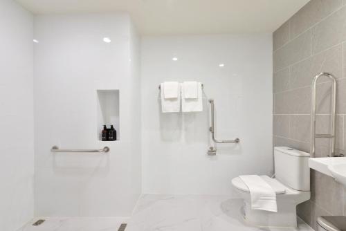 a white bathroom with a toilet and a sink at SENS Hotel Nonthaburi Bangbuathong in Nonthaburi