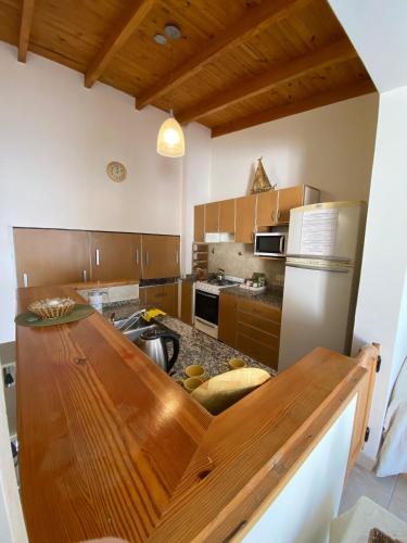 a kitchen with a wooden counter top and a refrigerator at Alem plaza apart in Comodoro Rivadavia