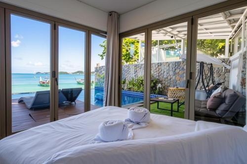a bedroom with a bed and a view of the ocean at Absolute Oceanfront Tara Villa Beachfront 4 Bed in Ban Saiyuan (1)