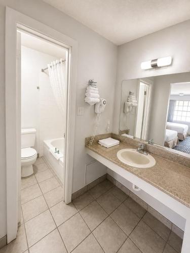a bathroom with a sink and a toilet and a mirror at Silver Queen Inn in Kingman