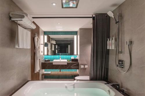 a bathroom with a tub and a sink at Le Meridien Phuket Beach Resort in Karon Beach