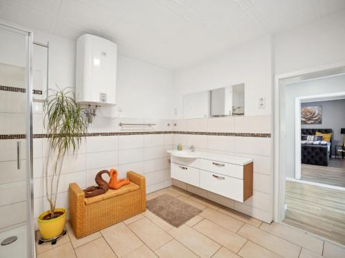 a white kitchen with a sink and a chair at Mompels in Rübeland