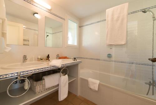a bathroom with a sink and a tub and a mirror at La Résidence du Moulin in Tourrettes-sur-Loup