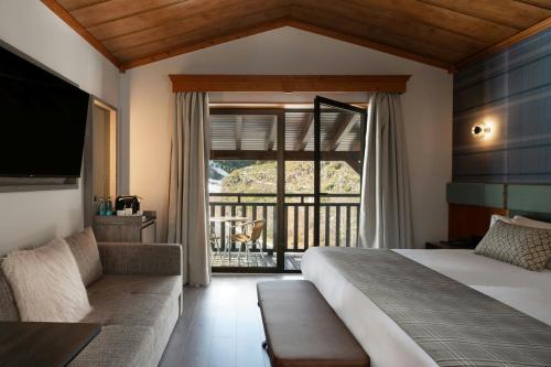 a bedroom with a bed and a view of a balcony at Hotel Euroski Mountain Resort & Spa in Soldeu