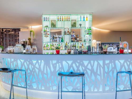 a blue bar with two stools in front of it at Novotel Setubal in Setúbal