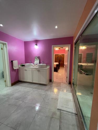 a purple bathroom with two sinks and a tub at Private Executive Master Suite - Parham, Antigua in Vernons