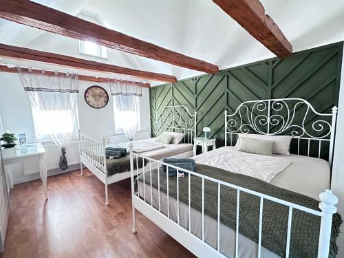 a bedroom with a white bed and a green wall at Suite House - Magnolia - Oak - Sage in Bayreuth