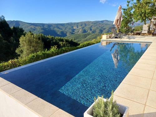 a swimming pool with a view of the mountains at Lugar dos Meandros 