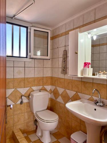 a bathroom with a toilet and a sink at Komi Seaside Living in Kómi