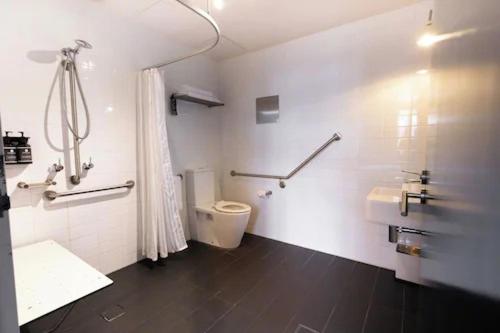 a bathroom with a shower and a toilet and a sink at Harbour Rocks by Ode Hotels in Sydney