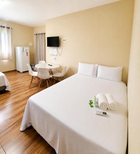 a bedroom with a large white bed with towels on it at Ondas do Preá - 700m da Praia - 12 km de Jeri in Prea