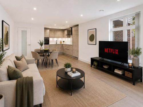a living room with a couch and a tv at 2 Bedroom Addenbrookes Apartment in Trumpington