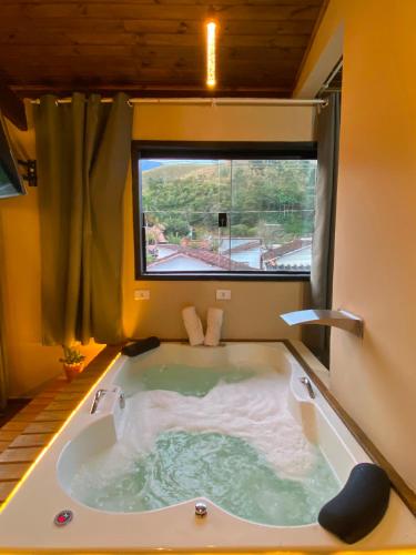 a jacuzzi tub in a room with a large window at Casa no Centro de São Francisco Xavier in São José dos Campos