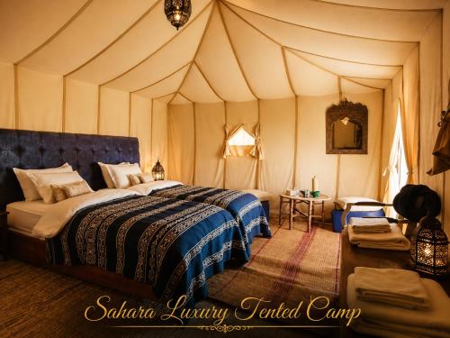 a bedroom with a bed in a tent at Sahara Luxury Tented Camp in Merzouga
