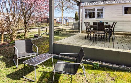 a deck with chairs and a table and a table and chairs at 2 Bedroom Cozy Stacaravan In Makkum in Makkum
