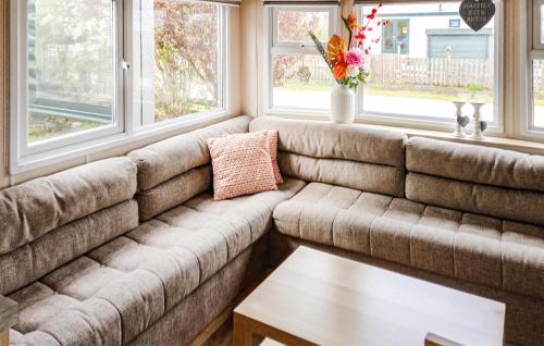 a couch in a living room with windows at 2 Bedroom Cozy Stacaravan In Makkum in Makkum