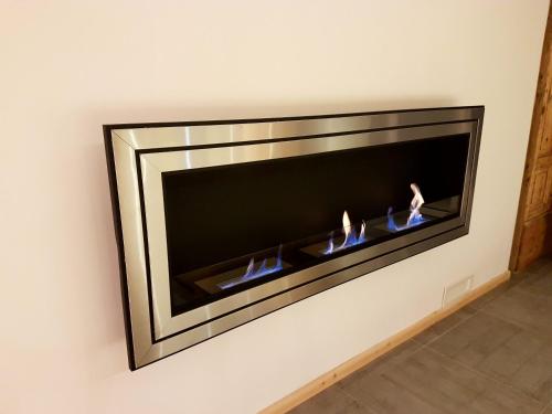 a fireplace in a wall with two fires at Aqua Apartments Spa Housemuhlbach in Sappada